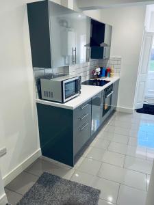 a kitchen with blue cabinets and a microwave at 21 ,North Street in Shrewsbury