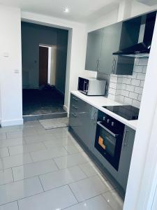 a kitchen with gray appliances and a white tile floor at 21 ,North Street in Shrewsbury