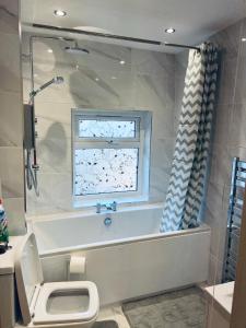 a bathroom with a tub and a toilet and a window at 21 ,North Street in Shrewsbury +12 photos