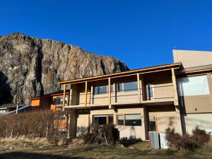 a house with a mountain in the background at Chalten Mountain Lofts 3 in El Chalten