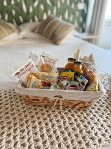 ルッカにあるNEW! -Verderame Rooms & Suite in Luccaのベッドの上に食べ物と飲み物のバスケット