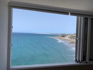 une fenêtre donnant sur une plage et l'océan dans l'établissement Ocean Breeze San Agustin, à San Agustín