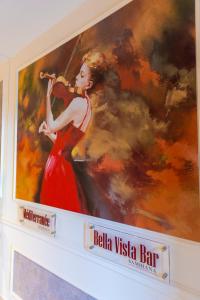 a painting of a woman in a red dress playing a violin at Leonardo Boutique Hotel Larnaca in Larnaca
