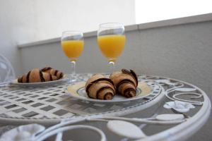 twee borden eten op een tafel met twee glazen sinaasappelsap bij Villa Fortuna in Podstrana