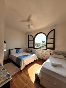 a bedroom with two beds and a window at Casa da Edna in Guarujá