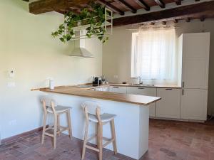 una cocina con 2 taburetes en un mostrador de cocina en NEW! -Verderame Rooms & Suite in Lucca, en Lucca