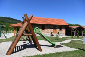 a playground with a slide in front of a house at MY WAY apartman i sobe in Saborsko
