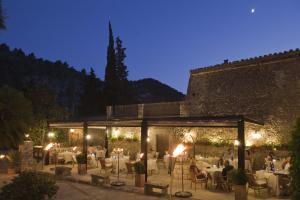 ein Restaurant mit weißen Tischen und Stühlen in der Nacht in der Unterkunft L’Hermitage Hotel & Spa in Orient