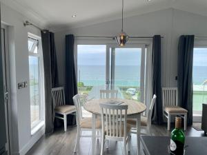 a dining room with a table and a view of the ocean at Hendre Coed Isaf Caravan Park in Barmouth