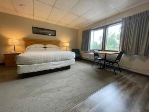 a hotel room with a bed and a table at Boulder Twin Lakes Inn in Boulder