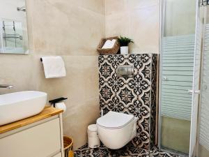 y baño con aseo, lavabo y ducha. en הפינה של טלי בנהריה - אירוח וספא בריאות מחומם en Nahariyya