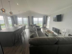 a living room filled with furniture and a large window at Hendre Coed Isaf Caravan Park in Barmouth