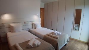 Habitación de hotel con 2 camas y toallas. en Amateur Runners en Água de Alto