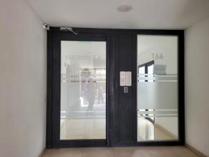 una puerta a una tienda con una persona en la ventana en Departamento Céntrico muy cómodo, en San Juan