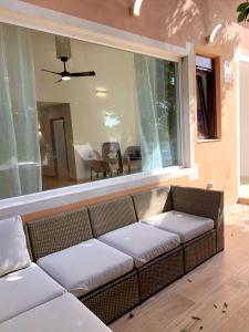 a couch in a living room with a large window at AMPLIA VIVIENDA NEW para12 pers a 4 min caminando de PLAYA con Terraza, Piscina Com, Wifi, Ventiladores de techo, Lavavajillas in Roquetas de Mar