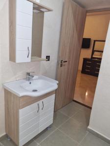 uma casa de banho com um lavatório branco e um espelho. em Villa atlas farm strictement pour les familles em Marrakech