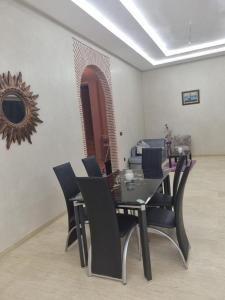 uma sala de jantar com uma mesa preta e cadeiras em Villa atlas farm strictement pour les familles em Marrakech