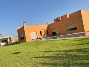 um edifício com um relvado à frente em Villa atlas farm strictement pour les familles em Marrakech