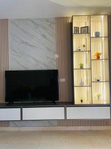a living room with a television on a white entertainment center at Hawana apartment in Salalah