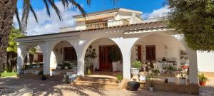 a white house with an archway in a yard at Romantico Wellness Casa Veronica in Elche