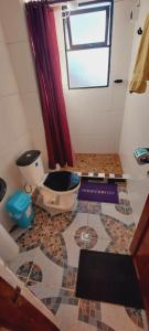 a bathroom with a toilet on a tiled floor at Suma Uta in Copacabana