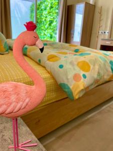 a pink flamingo standing in front of a bed at فلامينجو Flamingo in Abha