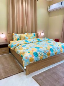 a bedroom with a large bed with a colorful comforter at فلامينجو Flamingo in Abha