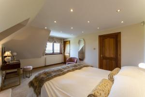 a bedroom with a large bed and a desk at St Michael's in Kippen