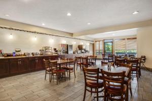 a restaurant with tables and chairs and a kitchen at Best Western Indian Oak in Chesterton