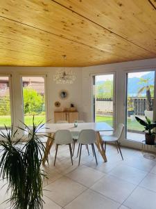 a dining room with a table and chairs and windows at Magnifique maison avec vue sur lac Léman in Saint-Legier-La Chiesaz