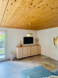 a living room with a tv on a wooden ceiling at Magnifique maison avec vue sur lac Léman in Saint-Legier-La Chiesaz