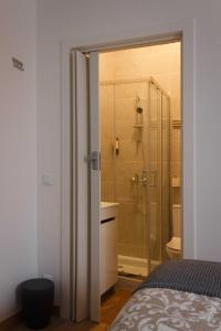 a bathroom with a shower and a bed in a room at Flor&Fidalgo Guest House in Sintra