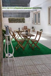 een patio met een tafel en stoelen op het gras bij Flor&Fidalgo Guest House in Sintra