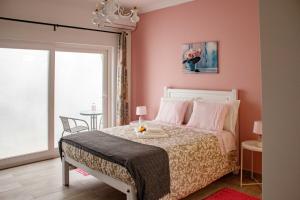 ein Schlafzimmer mit einem Bett und einer rosa Wand in der Unterkunft Flor&Fidalgo Guest House in Sintra
