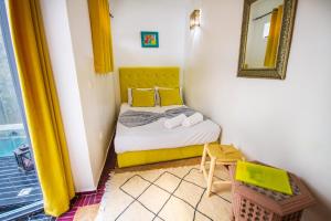 Dormitorio pequeño con cama y espejo en Riad Les Jardins des Lilas, en Marrakech