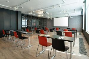 una sala de conferencias con mesas, sillas y una pizarra en Radisson RED Brussels, en Bruselas