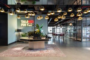 uma grande sala com uma mesa com plantas em Radisson RED Brussels em Bruxelas