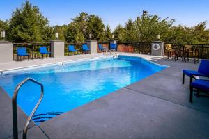 a large swimming pool with blue chairs and tables at Best Western Plus Beckley Inn in Beckley