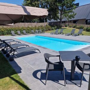 una piscina con sillas, una mesa y una mesa con sillas en Best Western L'Aquarium Arras Nord en Fresnes-lès-Montauban