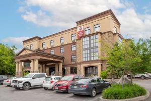 a building with cars parked in a parking lot at Best Western Plus Perth Parkside Inn & Spa in Perth