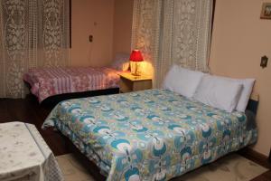 1 dormitorio con 2 camas y una lámpara en una mesa en Casa Mendes en Gramado