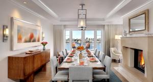 a dining room with a long table and a fireplace at Balboa Bay Resort in Newport Beach