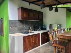 a kitchen with wooden cabinets and a table and a stove at Casa Única - Room with breakfast or Cabins with kitchen in La Laguna