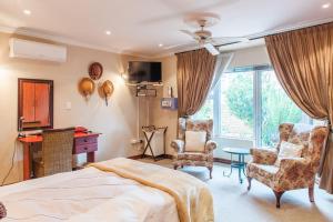 a bedroom with a bed and a desk and chairs at The Monte Carlo in Centurion