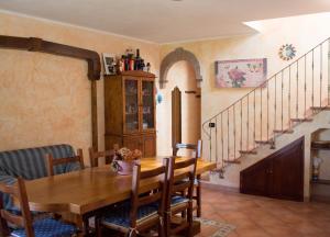 una sala da pranzo con tavolo in legno e scala di Brezza di Mare a Calasetta