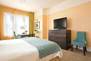 a hotel room with a bed and a flat screen tv at Hotel DeLuxe in Portland