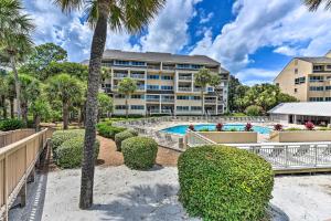 un complejo con piscina y palmeras en Palmetto Dunes Villa with Views Steps to Beach! en Hilton Head Island