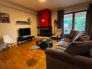 a living room with a couch and a television at The Spartan Penthouse in Sparti