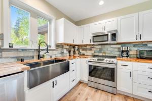 a kitchen with white cabinets and a stainless steel sink at Misty Meadow in Fraser