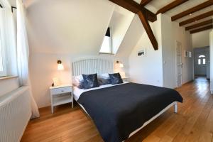 a bedroom with a large bed with black sheets and blue pillows at MY WAY apartman i sobe in Saborsko